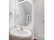 Half bath featuring a pedestal sink, modern faucet, and large mirror with decorative wall hardware at 9345 Hamel St, Charlotte, NC 28215