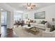 Bright living room features a ceiling fan, neutral paint, and hardwood flooring that flows into the dining area at 9345 Hamel St, Charlotte, NC 28215
