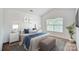 Bedroom featuring neutral paint, a large window, and stylish décor with a padded bench at the foot of the bed at 9345 Hamel St, Charlotte, NC 28215