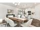 Elegant dining area with modern table and chairs, adjacent to an open kitchen with bar seating at 115 Sari St, Troutman, NC 28166