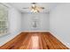 Sunny bedroom featuring hardwood floors, a ceiling fan, and a large window for natural light at 405 7Th St, Spencer, NC 28159