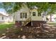 Back view of home with brick foundation, wood steps, and white siding at 405 7Th St, Spencer, NC 28159