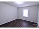 Simple bedroom with dark hardwood floors and a window at 602 Glenn St, Gastonia, NC 28052