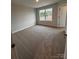 Cozy bedroom featuring neutral carpeting, a window with natural light, and a classic white door at 4069 Port Richmond Ave # 16, Gastonia, NC 28056