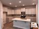 Modern kitchen featuring white cabinets, stainless steel appliances, a kitchen island and neutral backsplash at 4069 Port Richmond Ave # 16, Gastonia, NC 28056