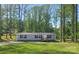 Charming home surrounded by a lush forest, featuring a well-manicured lawn and inviting front porch at 1128 Bethesda Rd, Statesville, NC 28677