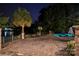 Night view of landscaped backyard and lake, with a brick patio and tropical trees at 1873 Farrow Dr, Rock Hill, SC 29732
