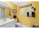 A bathroom with bright yellow walls, unique decor, and a large vanity area next to a toilet and shower stall at 1873 Farrow Dr, Rock Hill, SC 29732