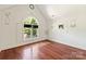 Bedroom featuring hardwood floors, art feature, vaulted ceiling, and window with shutter doors at 1873 Farrow Dr, Rock Hill, SC 29732