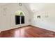 Bedroom featuring hardwood floors, art feature, vaulted ceiling, and window with shutter doors at 1873 Farrow Dr, Rock Hill, SC 29732