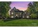 Stately home featuring manicured lawn and elegant architectural details against a colorful sunset sky at 1873 Farrow Dr, Rock Hill, SC 29732