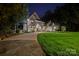 Stately home at night with a manicured lawn and a long, winding driveway at 1873 Farrow Dr, Rock Hill, SC 29732