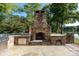 Spacious outdoor stone patio features a large stone fireplace, bar with grill, and lake views at 1873 Farrow Dr, Rock Hill, SC 29732