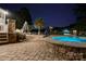 Backyard patio area featuring a stone hot tub, seating, and water views at night at 1873 Farrow Dr, Rock Hill, SC 29732