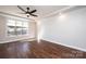 Bright bedroom featuring hardwood floors, a ceiling fan, and a large window at 3778 Rock Bridge Ne Dr, Conover, NC 28613