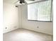 This bedroom has carpet, a window, and ceiling fan at 1300 Reece Rd # 302, Charlotte, NC 28209