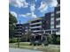 View of the building with manicured front yard and American flag against blue sky at 1300 Reece Rd # 302, Charlotte, NC 28209