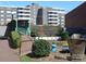 Building exterior with a green bridge, landscaping, and outdoor seating area at 1300 Reece Rd # 302, Charlotte, NC 28209