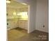 Bright kitchen features tile flooring, white appliances, and white cabinetry at 1300 Reece Rd # 302, Charlotte, NC 28209