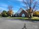 Charming brick home with a manicured lawn, mature trees, and blue skies at 11311 Olde Turnbury Ct, Charlotte, NC 28277