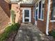 Inviting front porch with detailed trim, foliage, and a brick exterior at 11311 Olde Turnbury Ct, Charlotte, NC 28277