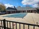 Community pool with a protective cover surrounded by a brick building and patio at 11311 Olde Turnbury Ct, Charlotte, NC 28277