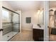 Bathroom with a large glass shower, dark vanity, and light tile floor at 4741 Nijinsky Ct, Charlotte, NC 28216