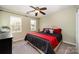 A nicely decorated bedroom with a large bed, ceiling fan, and two large windows at 4741 Nijinsky Ct, Charlotte, NC 28216