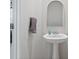 Simple bathroom with pedestal sink, arched mirror, and towel rack at 939 Cobbled Way, Fort Mill, SC 29715