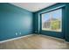 Cozy bedroom featuring light wood flooring, a bright window view, and calming blue walls at 939 Cobbled Way, Fort Mill, SC 29715