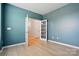 Bedroom with blue walls, wood floor, and white doors with glass panes at 939 Cobbled Way, Fort Mill, SC 29715