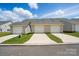 New home exterior with individual garages and well-manicured lawns under a sunny sky at 939 Cobbled Way, Fort Mill, SC 29715