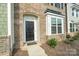 Townhome's front entrance with black door, brick facade, and a welcome mat at 939 Cobbled Way, Fort Mill, SC 29715