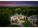Luxury estate featuring mature landscaping, circular driveway and sprawling lawn, and city skyline in the background at 2116 Woodhaven Rd, Charlotte, NC 28211