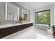 Sleek bathroom with double vanity, soaking tub, and large window with wooded views at 2116 Woodhaven Rd, Charlotte, NC 28211