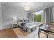 Comfortable bedroom with neutral tones, a large window with green view, and simple furnishings at 2116 Woodhaven Rd, Charlotte, NC 28211