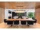 Stunning dining room showcasing wood-slatted wall and ceiling, modern lighting, and a large wood dining table with black chairs at 2116 Woodhaven Rd, Charlotte, NC 28211