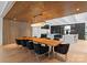 Bright dining area with wood-slatted accents, contemporary chandelier, and a rustic-style dining table surrounded by modern black chairs at 2116 Woodhaven Rd, Charlotte, NC 28211
