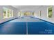 Spacious indoor sports court with blue flooring, white walls, and multiple windows for natural light at 2116 Woodhaven Rd, Charlotte, NC 28211