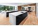 Open-concept kitchen featuring double waterfall islands with marble countertops and sleek black cabinetry, illuminated by natural light at 2116 Woodhaven Rd, Charlotte, NC 28211
