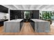 Bright kitchen with double islands featuring marble countertops, dark cabinetry, and stainless steel appliances for a modern, clean design at 2116 Woodhaven Rd, Charlotte, NC 28211