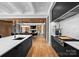 Modern kitchen with sleek black cabinets, marble countertops, and a view into the dining room, blending style and functionality at 2116 Woodhaven Rd, Charlotte, NC 28211