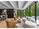 Elegant living room filled with plants, featuring a curved white sofa and tan leather chairs beside large windows for a bright, natural space at 2116 Woodhaven Rd, Charlotte, NC 28211