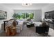 Bright living room featuring a large picture window with backyard views, white sectional, and modern decor at 2116 Woodhaven Rd, Charlotte, NC 28211