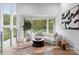 Living room with hardwood floors, decorative rug, couch and a large window showing wooded exterior at 2116 Woodhaven Rd, Charlotte, NC 28211