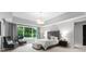 Elegant main bedroom with a tufted headboard, tray ceilings, and large windows showcasing a serene view at 2116 Woodhaven Rd, Charlotte, NC 28211