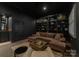 Dark-themed media room with sectional sofa and built-in shelving at 127 Tryon N St # 503, Charlotte, NC 28202