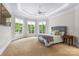 Tranquil bedroom with tray ceilings, ample natural light, and a cozy seating area at 130 Stonewall Beach Ln, Mooresville, NC 28117