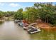 Picturesque boat dock on the water's edge with multiple slips and well-maintained boats for easy access to aquatic adventures at 130 Stonewall Beach Ln, Mooresville, NC 28117