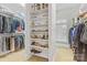 Spacious walk-in closet with custom shelving for shoes and clothes, plus a window for natural light at 130 Stonewall Beach Ln, Mooresville, NC 28117